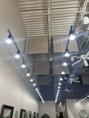 Track lighting and ceiling fans above a retail display area